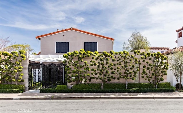 view of side of home with a gate and stucco siding