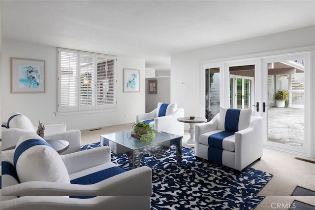 carpeted living room with visible vents and french doors