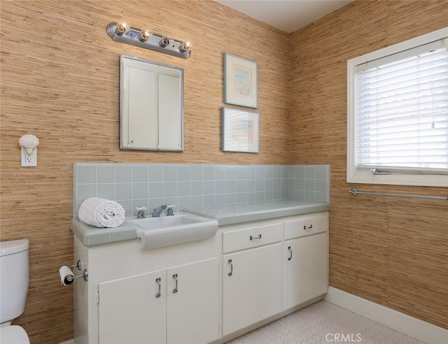 bathroom with vanity, toilet, and tasteful backsplash