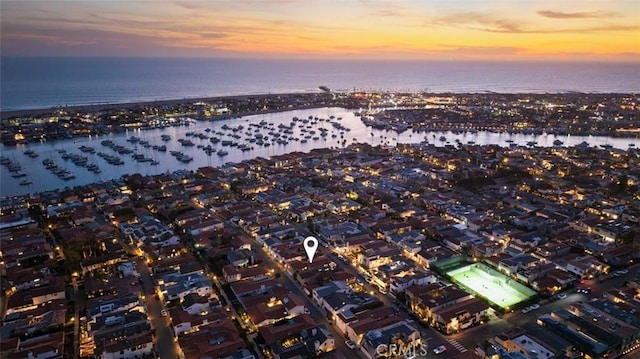 aerial view at dusk featuring a water view