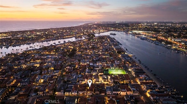 aerial view at dusk featuring a water view