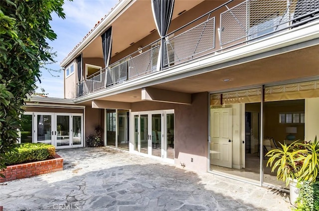 back of house with a patio, a balcony, stucco siding, and french doors
