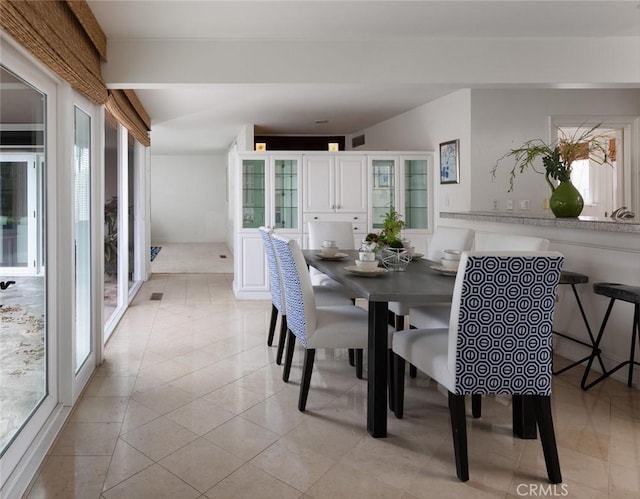 dining area with light tile patterned flooring, visible vents, and a wealth of natural light