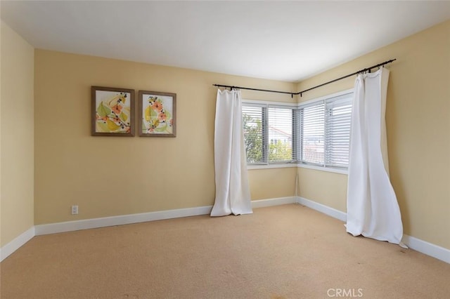 unfurnished room with carpet flooring and baseboards