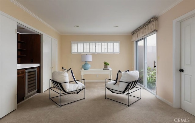 living area with beverage cooler, light carpet, baseboards, and crown molding