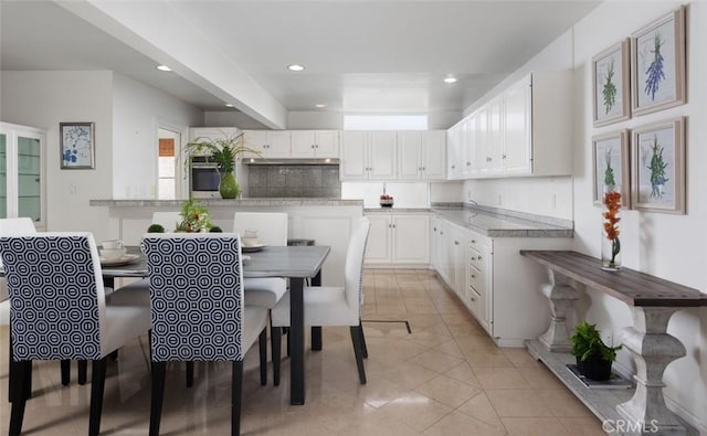 kitchen featuring light tile patterned flooring, oven, recessed lighting, light countertops, and white cabinets