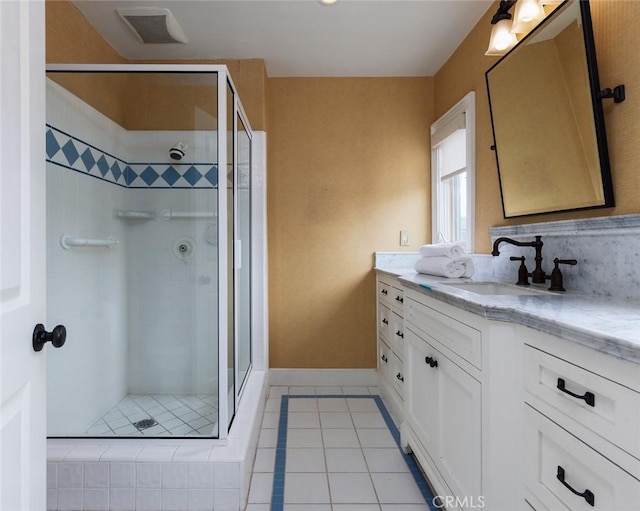 full bath with visible vents, tile patterned flooring, a shower stall, vanity, and baseboards