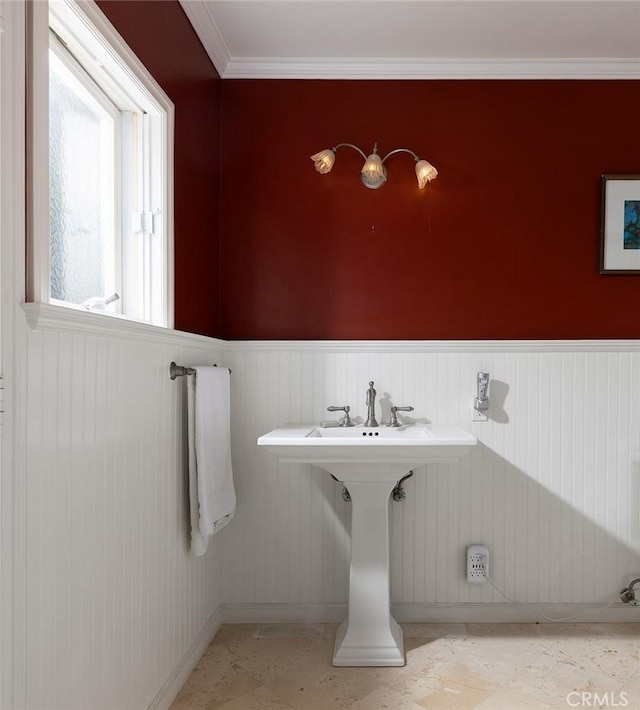 bathroom featuring a wainscoted wall and ornamental molding