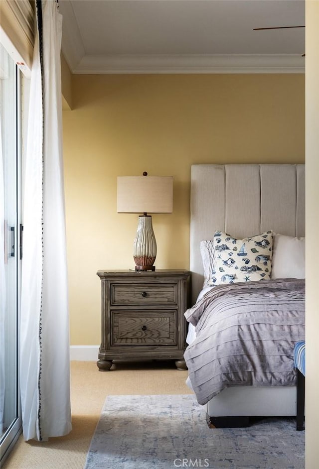 bedroom featuring light carpet, baseboards, and crown molding