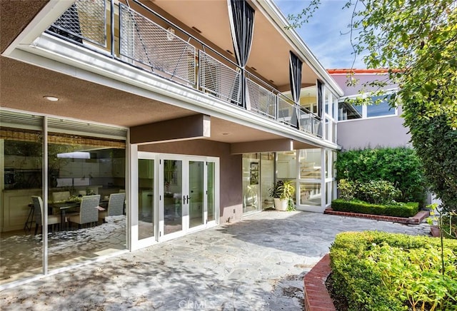 rear view of house featuring a patio and stucco siding