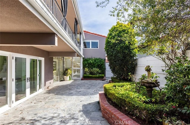 view of yard with french doors, fence, and a patio area