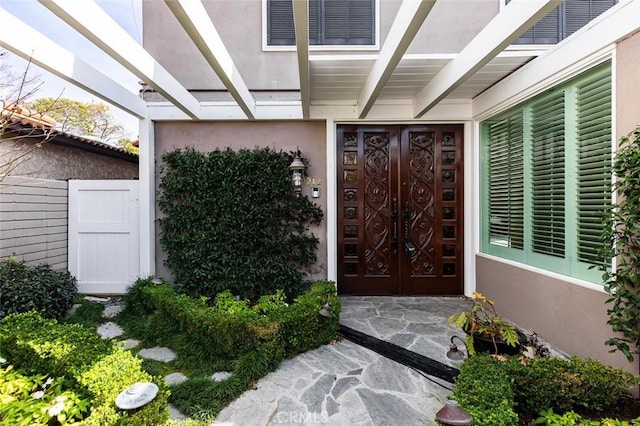 property entrance featuring visible vents and stucco siding