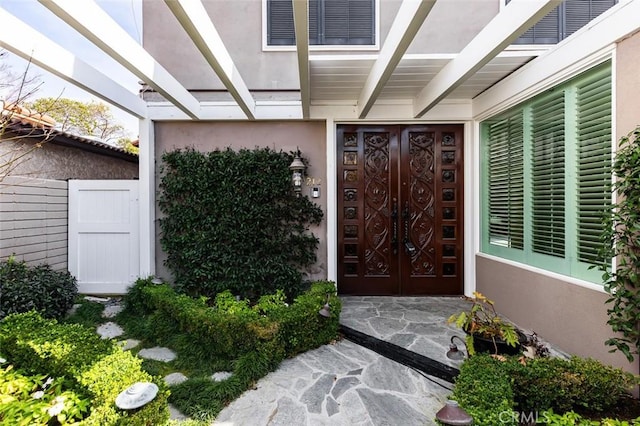 entrance to property featuring stucco siding