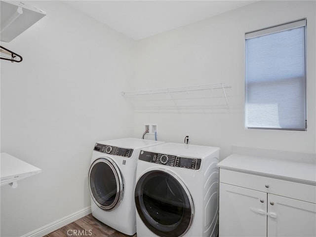 laundry room featuring dark wood-style flooring, cabinet space, independent washer and dryer, and baseboards