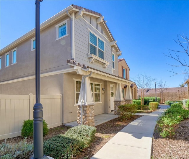 exterior space featuring fence and stucco siding