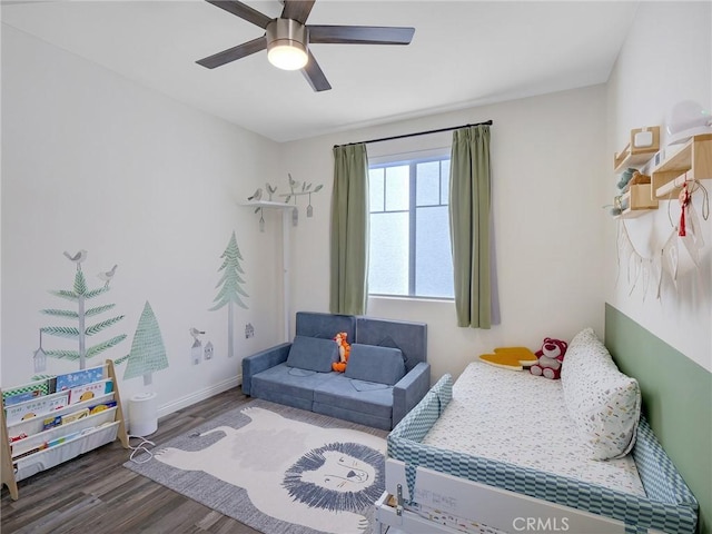 bedroom featuring ceiling fan, baseboards, and wood finished floors