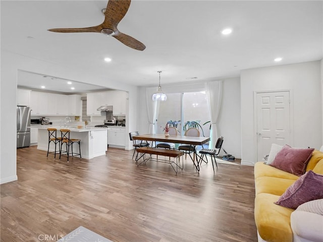 dining room featuring a ceiling fan, recessed lighting, baseboards, and wood finished floors