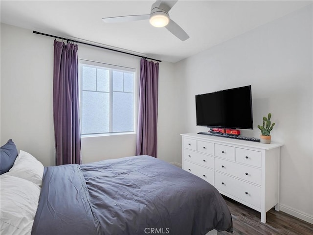 bedroom featuring dark wood-style flooring, a ceiling fan, and baseboards