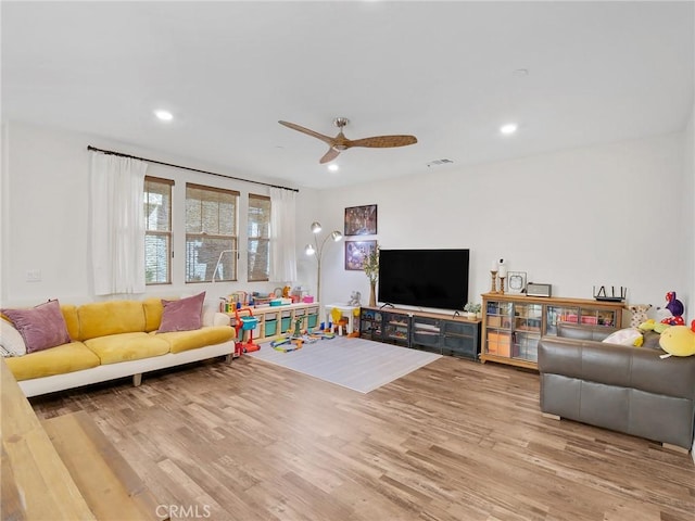 living area with a ceiling fan, wood finished floors, and recessed lighting