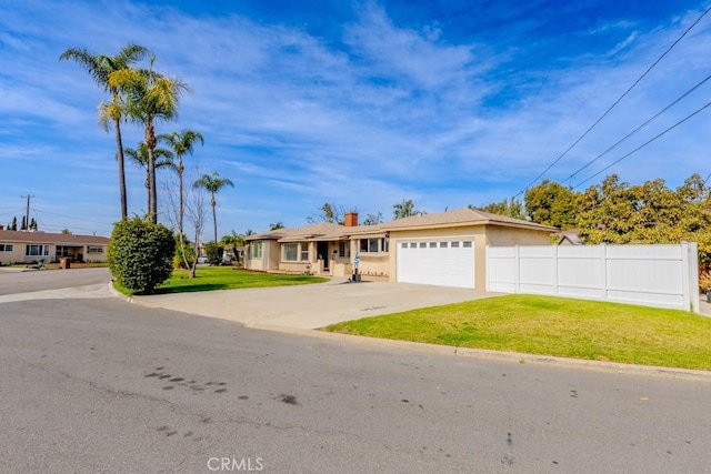 single story home featuring driveway, an attached garage, fence, a front yard, and stucco siding