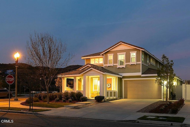 view of front of property with an attached garage, fence, and concrete driveway