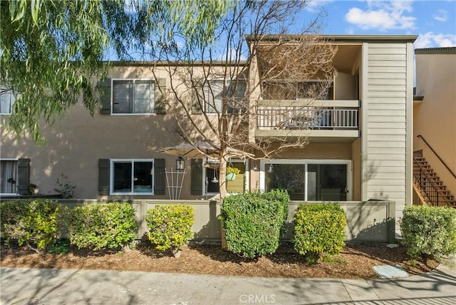 view of front of house with a balcony and stucco siding