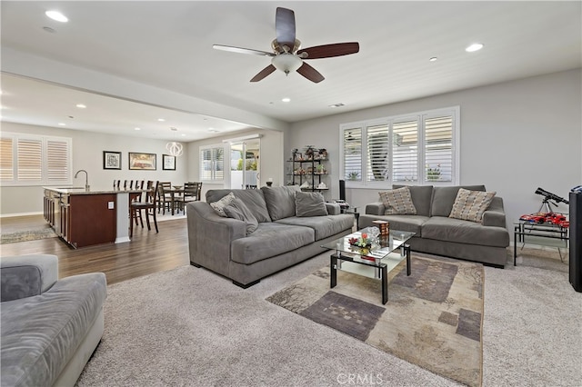 living area with recessed lighting, ceiling fan, and wood finished floors