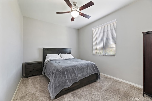 bedroom featuring baseboards, a ceiling fan, and light colored carpet