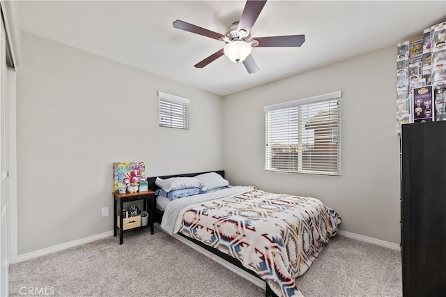 bedroom with light carpet, ceiling fan, and baseboards