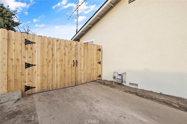 exterior space with stucco siding and a gate