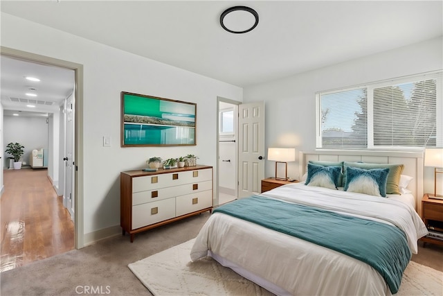 bedroom with baseboards and light colored carpet