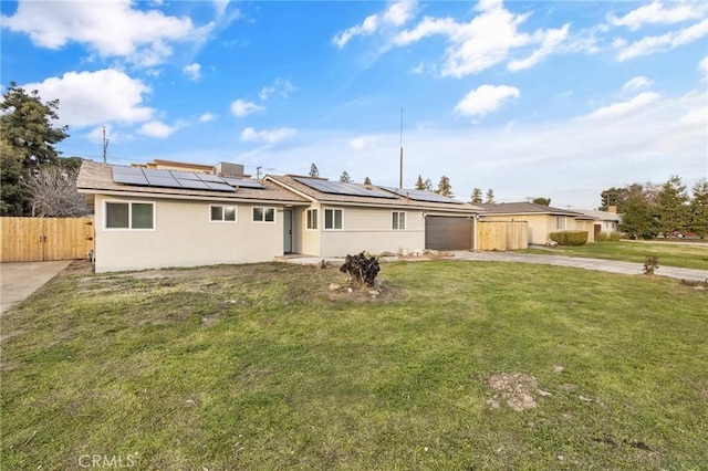 single story home with driveway, an attached garage, fence, solar panels, and a front yard