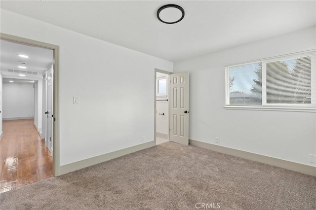 carpeted empty room with baseboards