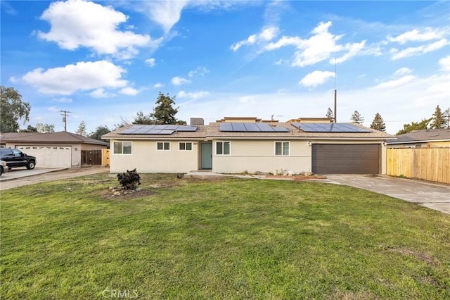 ranch-style home with solar panels, fence, a front lawn, and concrete driveway