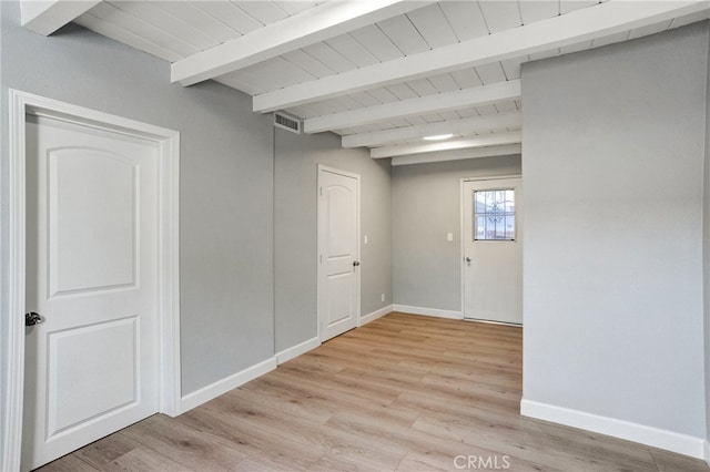 unfurnished room featuring visible vents, light wood-style flooring, wooden ceiling, beamed ceiling, and baseboards