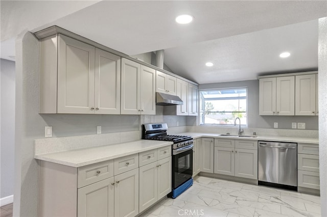 kitchen with under cabinet range hood, stainless steel appliances, a sink, marble finish floor, and light countertops