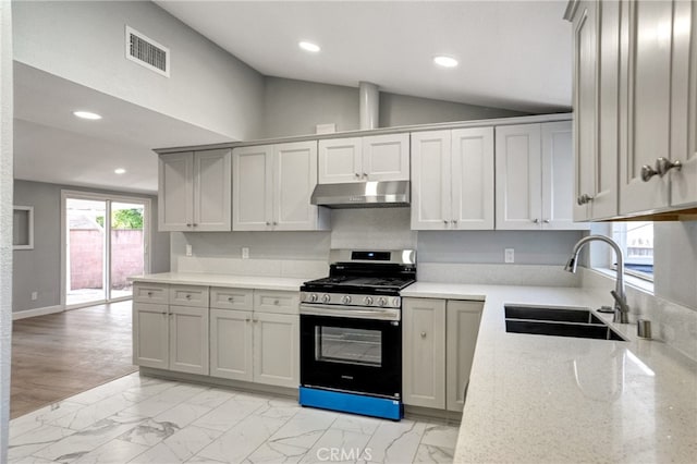 kitchen with marble finish floor, a sink, gas range, and under cabinet range hood