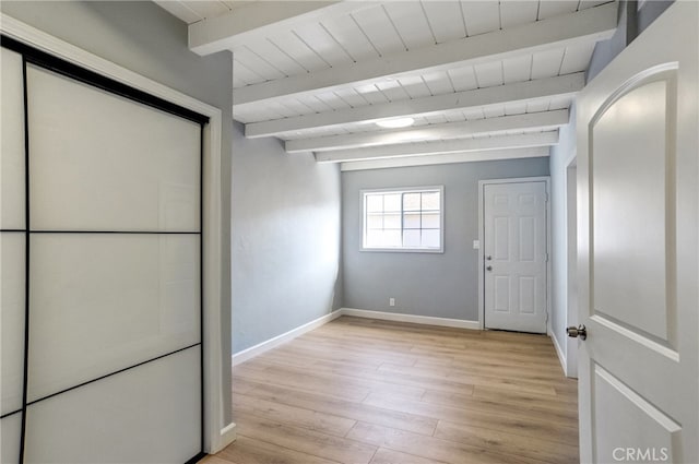 interior space with light wood-style floors, wood ceiling, baseboards, and beam ceiling