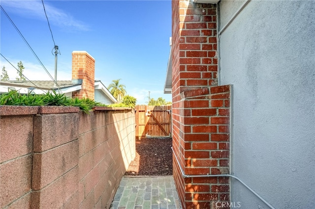 exterior space featuring stucco siding, fence, and brick siding