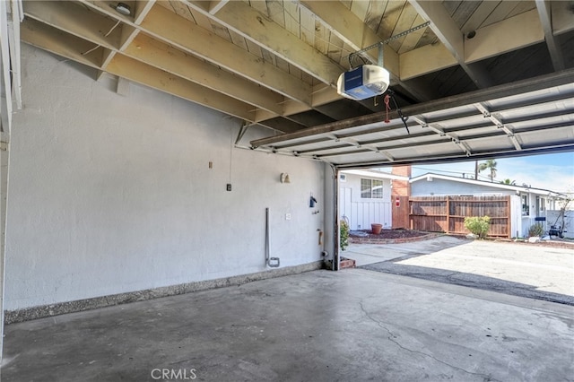 garage with fence and a garage door opener