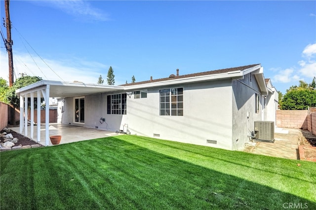 rear view of house with central air condition unit, a lawn, a hot tub, crawl space, and a patio area