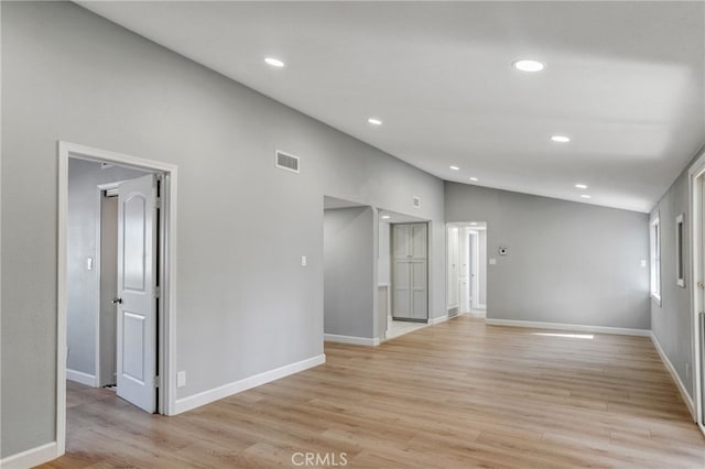 spare room with light wood-style floors, recessed lighting, vaulted ceiling, and baseboards