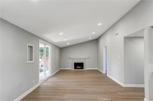 unfurnished living room with light wood-type flooring, a brick fireplace, baseboards, and recessed lighting