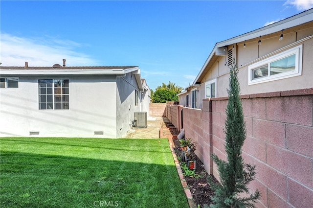 view of yard with a fenced backyard and central AC unit