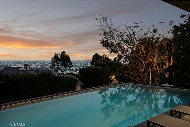 pool at dusk featuring an outdoor pool