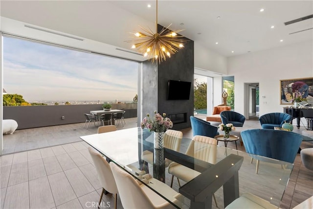 dining room featuring a notable chandelier, a high ceiling, recessed lighting, and light tile patterned floors