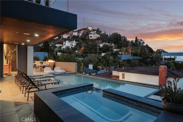 view of swimming pool featuring exterior bar, a patio, and a pool with connected hot tub