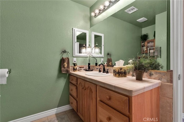 bathroom with tile patterned flooring, baseboards, vanity, and visible vents