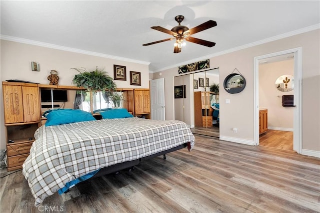 bedroom featuring ceiling fan, ornamental molding, baseboards, and wood finished floors