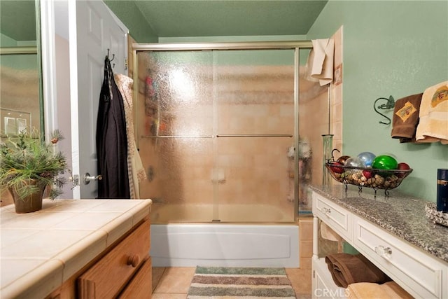 full bath featuring tile patterned flooring, combined bath / shower with glass door, and vanity